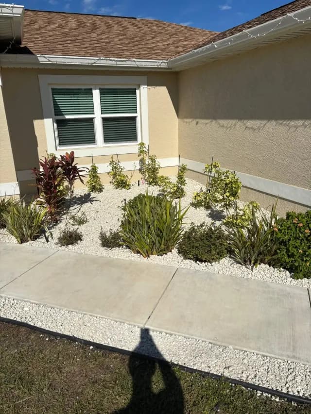 New planting bed with rock mulch along a home's corner