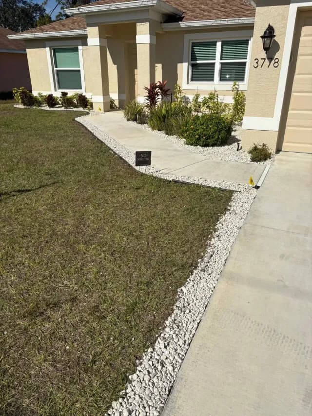 Clean white rock border edging a walkway and driveway