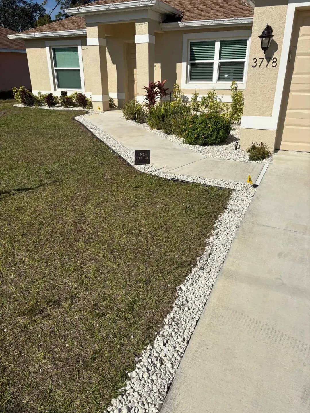Landscape bed with rock mulch and fresh plantings along a front walkway